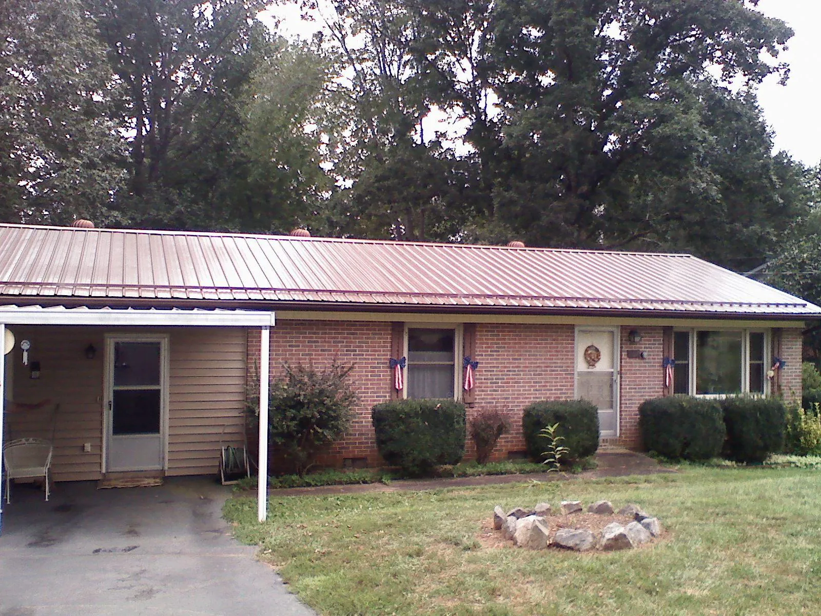 Bronze metal roof and carport on a brick ranch home — Roof Repair work by our crew in Delano